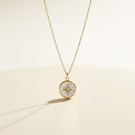 Gold necklace with a compass pendant on a beige background miminoo
