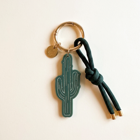 Keychain with cactus design and green rope on a beige background
