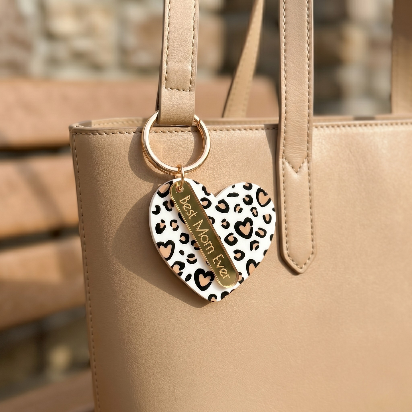 Heart-shaped keychain with leopard print design attached to a beige handbag by miminoo