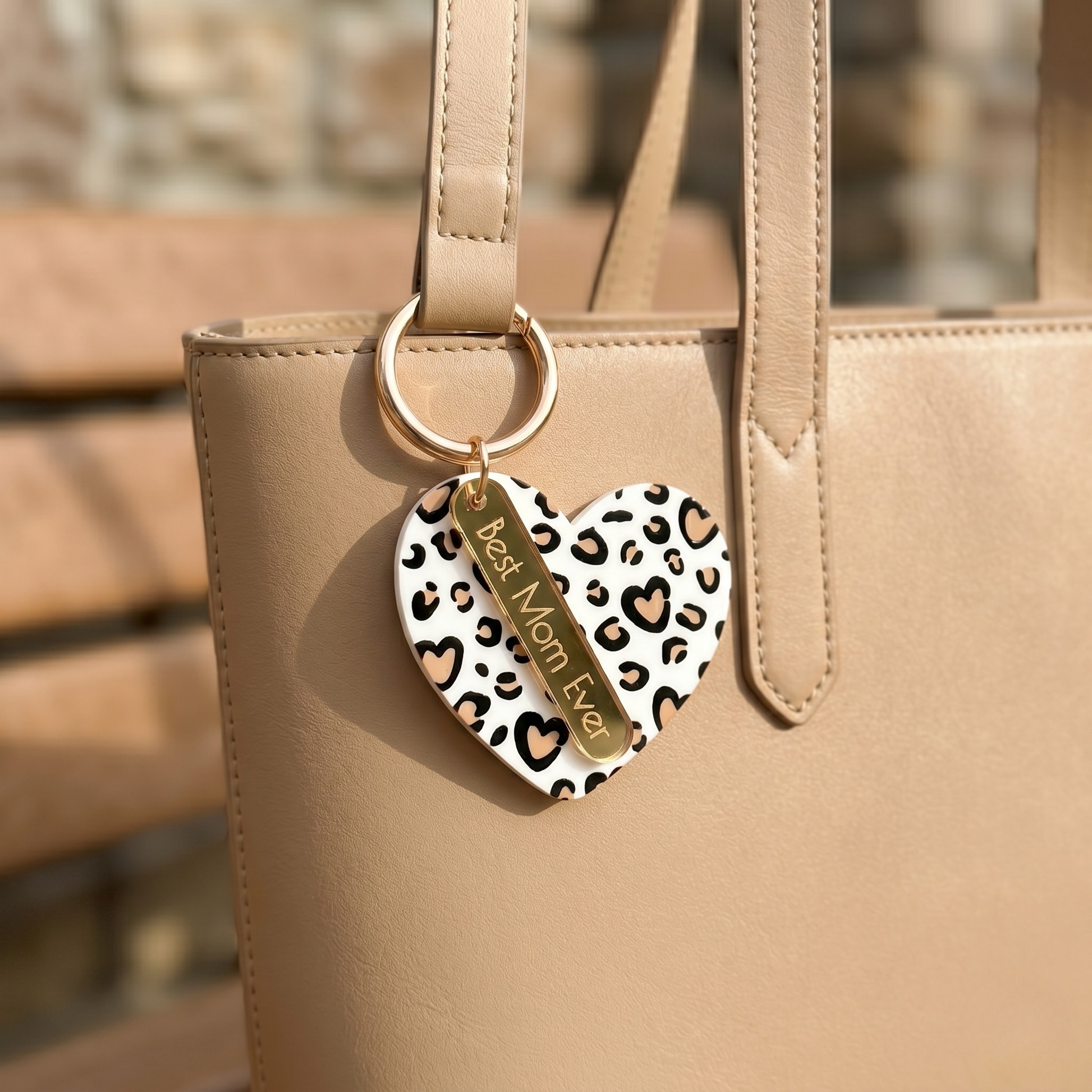 Heart-shaped keychain with leopard print design attached to a beige handbag by miminoo