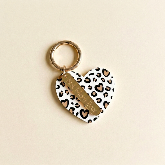Heart-shaped keychain with leopard print pattern and 'Best Mom Ever' text on a beige background