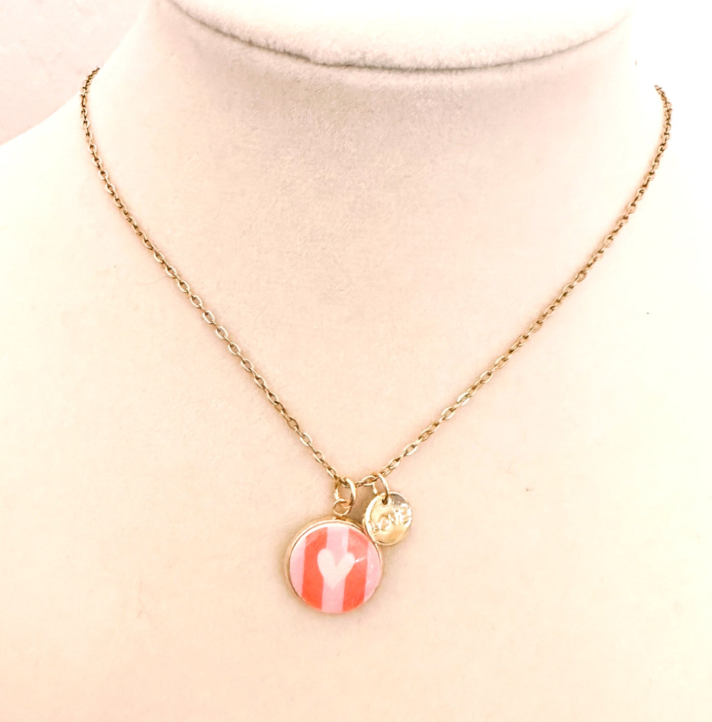 Gold trace chain necklace with pink striped round heart charm and "LOVE" charm