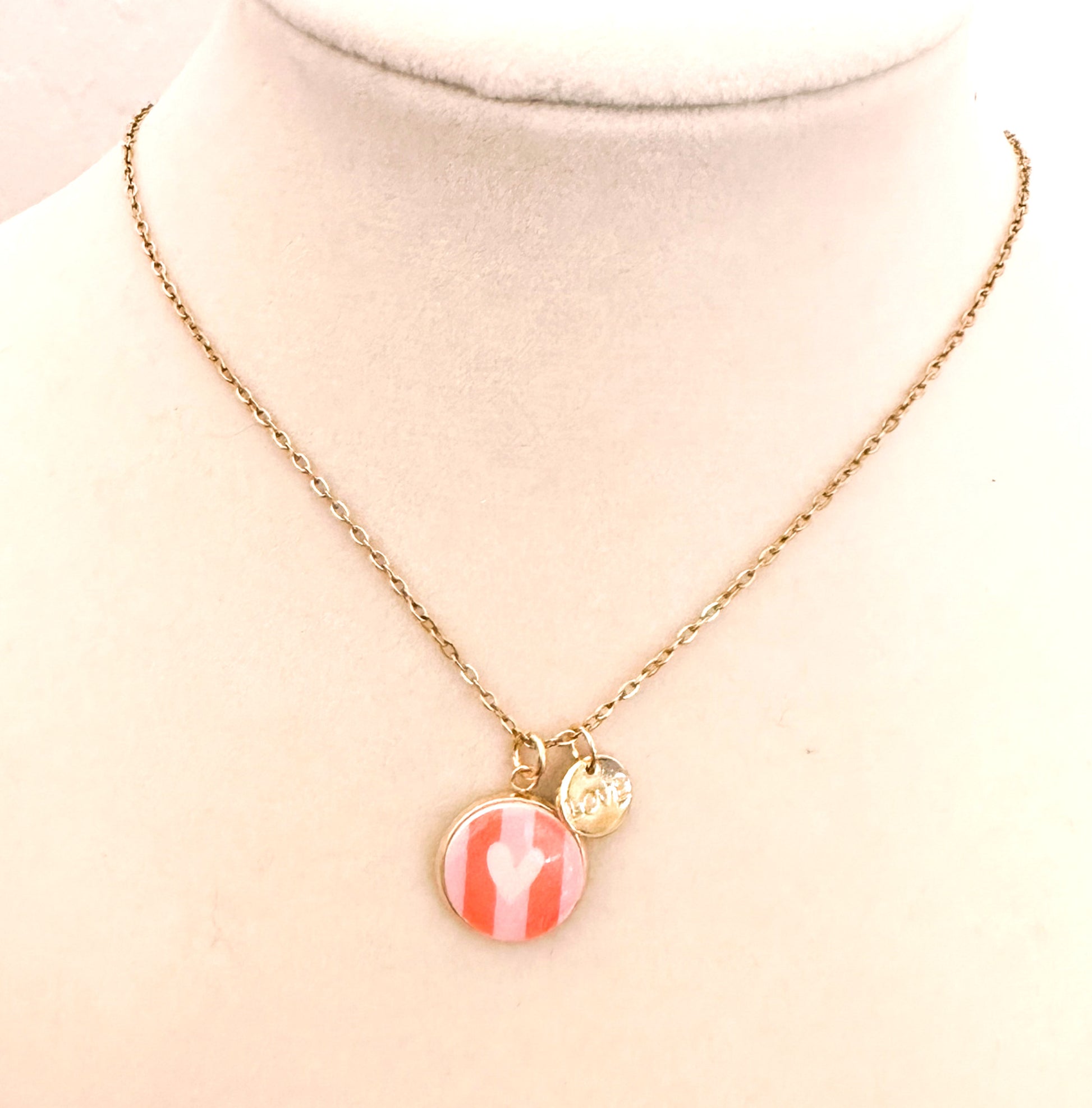 Gold trace chain necklace with pink striped round heart charm and "LOVE" charm